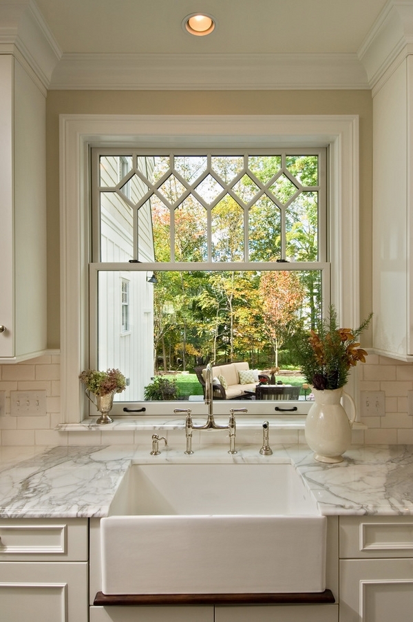 white bathroom windowsill featuring a potted cacti and bonsai trees