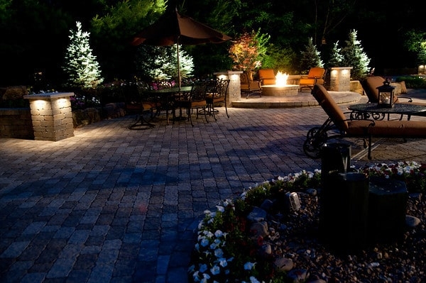 features a fire pit, walls and a dining area by  BAC McCune Outdoor Living