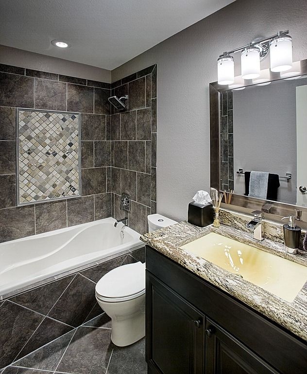 A gorgeous bathroom remodel with a tile shower, white trim and a fresh coat  of blue paint