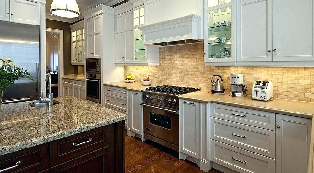 Pops of red bring life to this gorgeous white and gray kitchen featuring a Wolf range topped with a red kettle and pot positioned in front of a wall covered